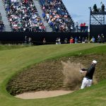 Player hitting a sand wedge to escape a steep bunker
