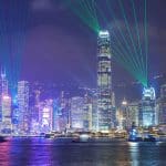 View over Victoria Harbour to Hong Kong's skyline at night with light shows